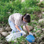 在卵礫石堆中藍(lán)色醒目的「皮球」，吸引了小朋友前去查看並拾起，一點(diǎn)一滴還給河川乾淨(jìng)的面貌。