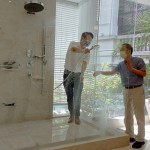 新業(yè)建設(shè)卓勝隆董事長(zhǎng)（右）伸手測(cè)試三段式水流變化為肌膚帶來(lái)的觸感，親身體驗(yàn)，精選出舒心的衛(wèi)浴設(shè)備。