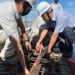 新業(yè)建設名譽董事長穆椿松先生（圖前排右一），於樓頂安裝「噴金漆鋼筋」即為上樑，古有云「上樑有如人之加冠」，不論在建築進度及民俗學上都極具意義。