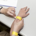 活動(dòng)開始之前，工作人員協(xié)助大、小朋友們戴上分組的幸運(yùn)手環(huán)。