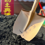 新業(yè)建設 穆椿松 創(chuàng)辦人 於金鏟上簽名留念，開工誌慶，步步啟程。