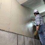 職人一遍一遍的在建築立面抹開，事先的預留溝縫也是門學問。