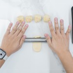 初體驗包月餅的新業(yè)同仁，一步步跟著講師的詳細教學，從秤重、桿捲、包覆、裝飾，到送入烤箱。 