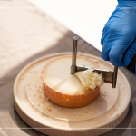 半硬質(zhì)家族的修道士(TETE DE MOINE)，呈小型鼓狀，外殼有點(diǎn)油膩、呈褐色，乳酪團(tuán)結(jié)實(shí)且濃郁，隨著熟成顏色會(huì)加深，以轉(zhuǎn)臺(tái)式乳酪削切器，削成花摺邊小花苞。