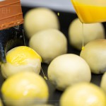 刷上蛋黃液，點上芝麻裝飾，圓潤蓬鬆的蛋黃酥即將穿上金黃酥脆的外衣。