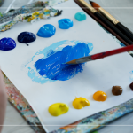 飽和多彩的顏料，在紙製調色盤上，用畫筆輕輕均勻塗開，準備在素色畫布上恣意揮灑。