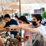 從攤販?zhǔn)种薪舆^最適合午後享用的輕食，攤販同時將心意以雙手一同遞上，彼此的這份互動是盛夏美好的一景。